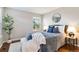 Charming bedroom featuring a luxurious gray comforter with throw blanket and pillows, complemented by wood floors and a round mirror at 2645 S Xanadu Way # D, Aurora, CO 80014