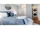 Comfortable bedroom featuring a luxurious gray comforter, stylish accent pillows, and convenient access to in-unit washer and dryer at 2645 S Xanadu Way # D, Aurora, CO 80014