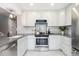 Bright, renovated kitchen featuring white cabinets, tile backsplash and stainless appliances at 2645 S Xanadu Way # D, Aurora, CO 80014