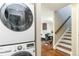 Convenient in-unit laundry with updated machines, complemented by an open floor plan leading to a dining area and staircase at 2645 S Xanadu Way # D, Aurora, CO 80014