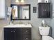 Clean bathroom with dark vanity, white tile, and a bathtub at 4557 S Yank St, Morrison, CO 80465