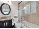 Bathroom with a sliding glass shower door, built-in tub, granite counters and decorative mirror at 7600 Kline Dr, Arvada, CO 80005