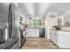 Well-lit kitchen with white cabinets, stainless steel appliances, granite countertops, and views of the back yard at 7600 Kline Dr, Arvada, CO 80005