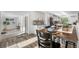 Bright kitchen and breakfast nook with stainless steel appliances, white cabinets, and wood flooring at 7600 Kline Dr, Arvada, CO 80005