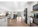 Open-concept living space with fireplace, dining area, and access to kitchen with stainless steel appliances at 7600 Kline Dr, Arvada, CO 80005