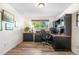 Comfortable office with a large window, wood floors, built-in shelves, and traditional black wood trim at 7600 Kline Dr, Arvada, CO 80005