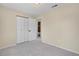 A carpeted bedroom with a closet and an open door to the bathroom at 15650 E Eldorado Dr, Aurora, CO 80013