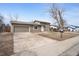 Wide angle shot of a brown house with driveway, garage, and small yard at 15650 E Eldorado Dr, Aurora, CO 80013