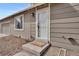 Tan house featuring a white front door with a screen and a 