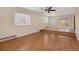 Sunlit living room features beautiful hardwood floors, modern ceiling fan, and access to the backyard through sliding doors at 15650 E Eldorado Dr, Aurora, CO 80013
