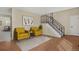 Staged living room features sleek staircase and two armchairs with decorative art at 15650 E Eldorado Dr, Aurora, CO 80013