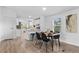 Bright dining room with wood floors, natural light and modern decor leading to kitchen with white cabinetry at 652 Verdos Dr, Elizabeth, CO 80107