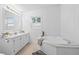 Well-lit main bathroom features a soaking tub, dual vanity, and modern fixtures at 652 Verdos Dr, Elizabeth, CO 80107