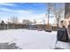 Snowy backyard with trampoline and fire pit area at 1381 Mariposa Dr, Denver, CO 80221