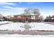 Brick ranch home with a modern fenced yard, snowy landscape, and a walkway to the entrance at 1381 Mariposa Dr, Denver, CO 80221