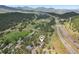 Aerial view of the property nestled in a forested area with a highway nearby at 30206 Telluride Ln, Evergreen, CO 80439