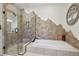 Spa-like bathroom features a glass-enclosed shower and a luxurious soaking tub with wall design at 30206 Telluride Ln, Evergreen, CO 80439
