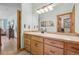 Bright bathroom with wood cabinets, large mirror, and good lighting, with view of adjoining rooms at 30206 Telluride Ln, Evergreen, CO 80439