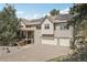 Beautiful two-story home with a three car garage, covered front porch, and solar panels on the roof at 30206 Telluride Ln, Evergreen, CO 80439