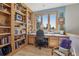 Cozy home office with custom built-in shelving, a large window, and desk, with ample light at 30206 Telluride Ln, Evergreen, CO 80439