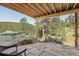 Outdoor patio featuring stone floors, a hot tub, and wood views of the surrounding forest at 30206 Telluride Ln, Evergreen, CO 80439