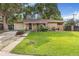 Charming ranch-style home with a well-maintained lawn and colorful flowerbeds enhancing the curb appeal at 111 S Eaton St, Lakewood, CO 80226