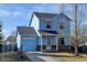 Charming two-story blue home featuring stone accents, an attached garage, and a well-maintained front yard at 7970 Gorham Ct, Frederick, CO 80530