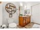 Well-lit bathroom with stylish floating shelves, a wood vanity and full sized mirror above sink at 833 E 98 Ave # 204, Thornton, CO 80229