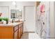 Bright bathroom featuring a wood vanity, decorative floral shower curtain and a full-sized mirror at 833 E 98 Ave # 204, Thornton, CO 80229
