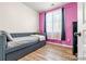 Bright bedroom featuring a daybed, a colorful accent wall and wood look flooring at 833 E 98 Ave # 204, Thornton, CO 80229