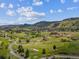 Stunning aerial view of lush golf course community nestled in rolling hills with beautiful blue sky at 10506 Brown Fox Trl, Littleton, CO 80125