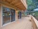 Wide wooden deck featuring multiple sliding glass doors, offering great outdoor living and views of the lush surroundings at 10506 Brown Fox Trl, Littleton, CO 80125