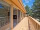 Expansive wooden deck with multiple sliding glass doors, offering seamless indoor-outdoor living and scenic backyard views at 10506 Brown Fox Trl, Littleton, CO 80125