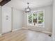 Bright dining room with light wood floors, modern light fixture, and large window with view at 10506 Brown Fox Trl, Littleton, CO 80125