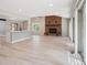 Open concept living room and kitchen features bright windows, wood flooring, and a brick fireplace at 10506 Brown Fox Trl, Littleton, CO 80125