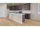 Open concept kitchen with island, dark cabinetry, and white quartz countertops at 21239 E 62Nd Ave, Aurora, CO 80019