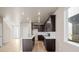 Modern kitchen with dark cabinets, white countertops, and an open layout at 21239 E 62Nd Ave, Aurora, CO 80019