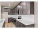 Modern kitchen with dark cabinets, white countertops, and an eat-in island at 21239 E 62Nd Ave, Aurora, CO 80019