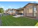 Exterior shot of backyard, featuring a manicured lawn and patio at 12938 Bridge View Ln, Parker, CO 80134