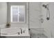 Bright bathroom with a soaking tub, walk-in shower and a window with blinds at 12938 Bridge View Ln, Parker, CO 80134
