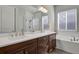 Elegant bathroom with double vanity, soaking tub, and glass-enclosed shower at 12938 Bridge View Ln, Parker, CO 80134