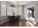 Bright dining area featuring dark wood floors, a chandelier, and sliding glass doors to the outside at 12938 Bridge View Ln, Parker, CO 80134