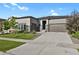 Traditional two-story home featuring a two-car garage, manicured lawn, and stone exterior accents at 12938 Bridge View Ln, Parker, CO 80134