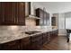 Stylish kitchen with granite countertops, custom backsplash, stainless steel range hood, and gas cooktop at 12938 Bridge View Ln, Parker, CO 80134