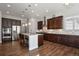 Spacious kitchen with dark wood cabinets, stainless steel appliances, and a large center island at 12938 Bridge View Ln, Parker, CO 80134