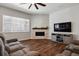Modern living room showcasing hardwood floors, a large TV, and a decorative fireplace at 12938 Bridge View Ln, Parker, CO 80134