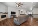 Open-concept living room with dark wood floors, a fireplace, and a view of the staircase at 12938 Bridge View Ln, Parker, CO 80134