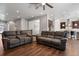 Open-concept living room with dark wood floors, a ceiling fan, and views into the kitchen and dining area at 12938 Bridge View Ln, Parker, CO 80134