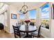 Bright dining area featuring a round table, modern chandelier, and views of the outdoors through large windows at 12457 Topaz Vista Way, Castle Pines, CO 80108