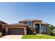 Elegant two-story home featuring stone accents, manicured lawn, and an attached two-car garage at 12457 Topaz Vista Way, Castle Pines, CO 80108